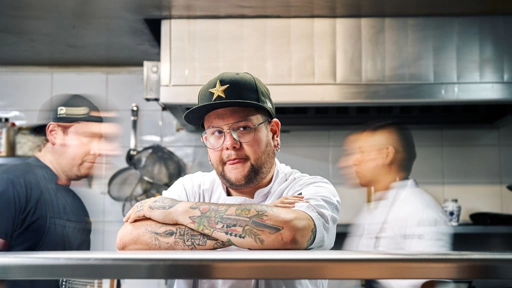 Portrait éditorial du Chef Émilien Vasseur dans sa cuisine, éclairé en clair-obscur.